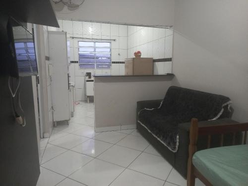 a small kitchen with a couch in a room at Pousada do Bene - Aluguel Casa in Guarujá