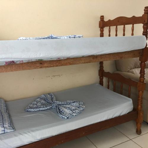 a pair of bunk beds with a hat on the bottom bunk at Pousada do Bene - Aluguel Casa in Guarujá