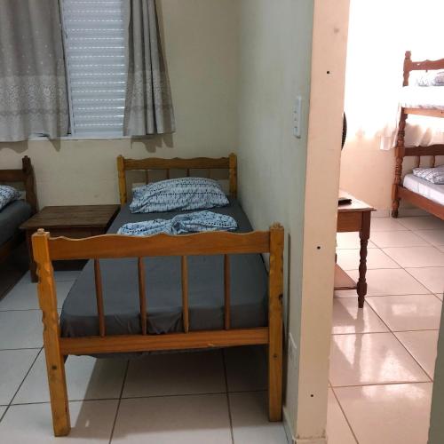 a wooden bunk bed in a room with a window at Pousada do Bene - Aluguel Casa in Guarujá