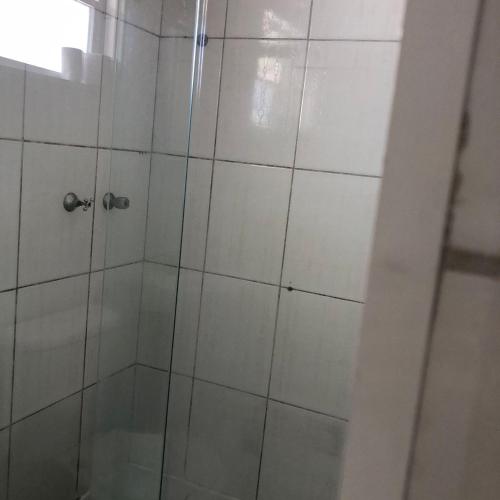 a shower with a glass door in a bathroom at Pousada do Bene - Aluguel Casa in Guarujá