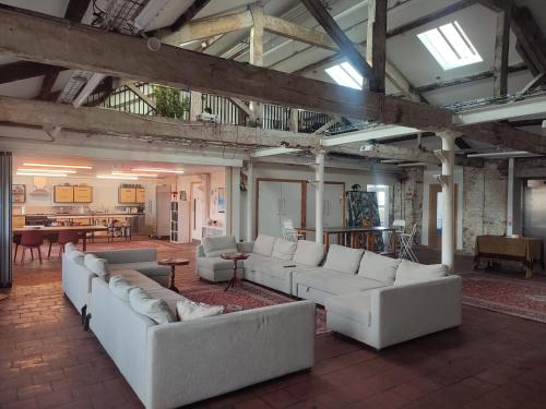 a large living room with white couches and tables at Islington Mill in Manchester