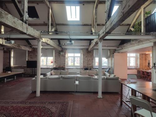 a large living room with couches and tables and windows at Islington Mill in Manchester