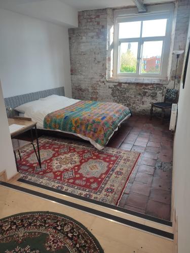 a bedroom with a bed and a table and a rug at Islington Mill in Manchester