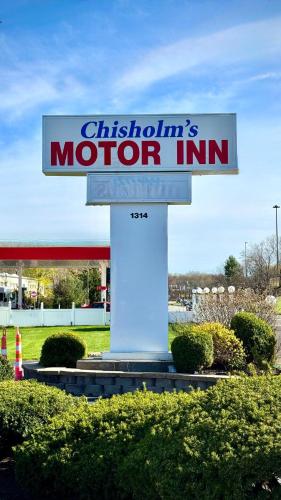 a sign for a motor inn in front of a gas station at Chisholm's Motor Inn in Saugus