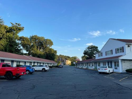 a parking lot with cars parked in front of buildings at Chisholm's Motor Inn in Saugus