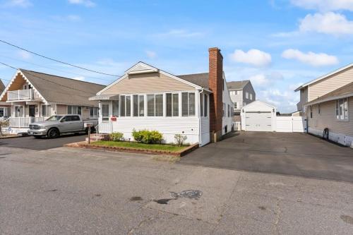 a house with a car parked in a parking lot at Harris Ave Hideaway Private Deck Near Marina in Hampton