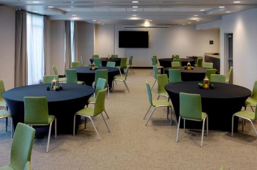 a conference room with tables and chairs and a screen at Snoqualmie Inn by Hotel America in Snoqualmie