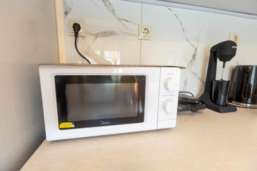 a microwave sitting on top of a kitchen counter at Aegean Lesvos Maisonette in Mytilini