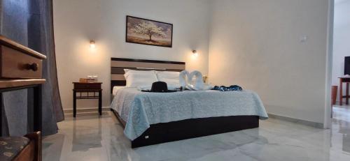 a bedroom with a bed with a blue blanket at La Maison de Christine -Adults Only in Chrysi Ammoudia