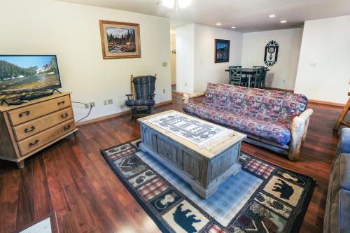 a living room with a couch and a tv at Sunnyside Knoll- 6 cabin in Estes Park