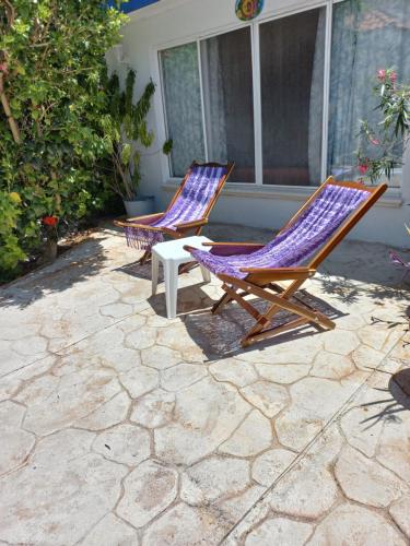 two lounge chairs and a table on a patio at Purple Lotus Cozumel in Cozumel