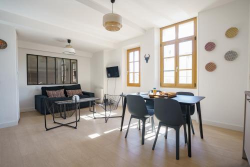 un salon avec une table, des chaises et un canapé dans l'établissement Le nid de la rue Mailly, à Perpignan
