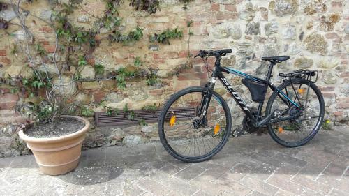 a bicycle parked next to a stone wall at Bosco Della Spina in Murlo
