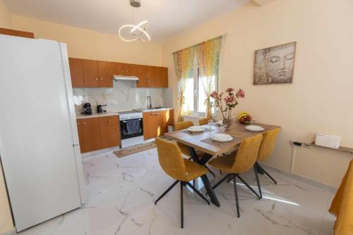 a kitchen with a table with chairs and a refrigerator at Aegean Lesvos Maisonette in Mytilini