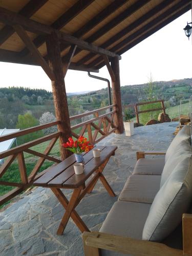 a patio with couches and a table with flowers on it at Aroniowe Wzgórze in Berezka