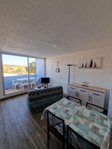 un salon avec une table et un canapé dans l'établissement Appartement Narbonne plage, à Narbonne