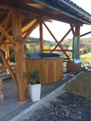 a large hot tub under a wooden pavilion at Aroniowe Wzgórze in Berezka