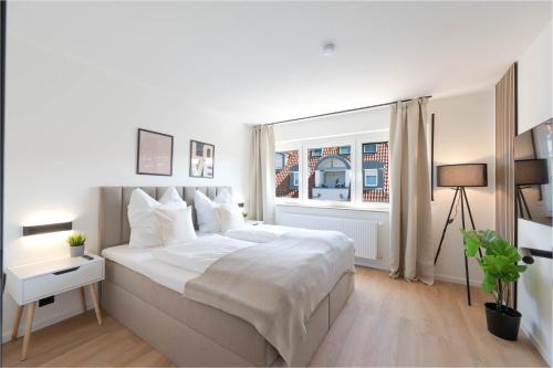 a white bedroom with a large bed and a window at Malu Rooms - im Zentrum, Kostenloser Parkplatz, Balkon, Netflix, 24h Checkin in Ludwigsburg