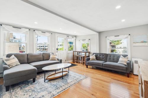 a living room with two couches and a table at Beachfront Parking Salisbury Beach Retreat in Salisbury