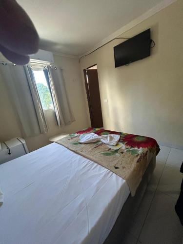a bedroom with a large white bed with a television on the wall at Pousada Inn Blue Horizon in Porto De Galinhas