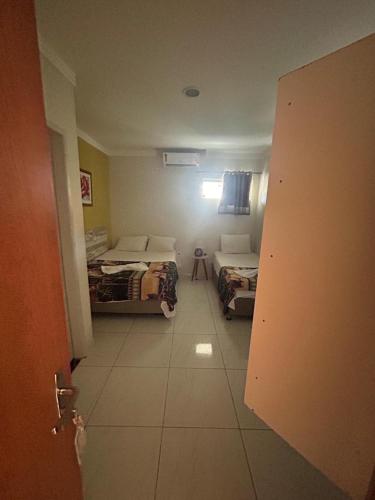 a room with two beds and a door to a bedroom at Pousada Inn Blue Horizon in Porto De Galinhas