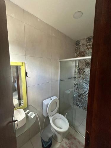 a bathroom with a toilet and a glass shower at Pousada Inn Blue Horizon in Porto De Galinhas