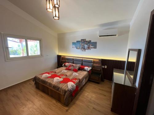 a bedroom with a large bed with red pillows at Amoun sea view in Qaryat Shurūq