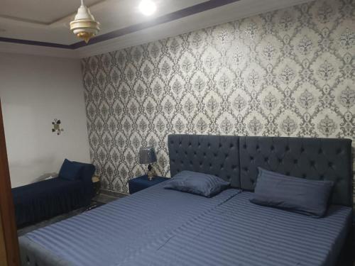 una camera da letto con un letto con cuscini blu di 2 bed apartment a Islamabad