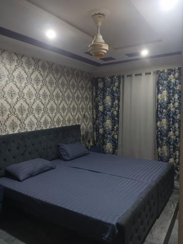 sypialnia z dużym łóżkiem z niebieskimi prześcieradłami w obiekcie 2 bed apartment w mieście Islamabad