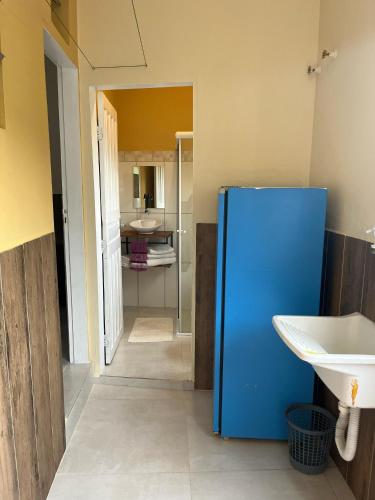 ein blauer Kühlschrank in einem Badezimmer mit Waschbecken in der Unterkunft Ao Mare in São Francisco