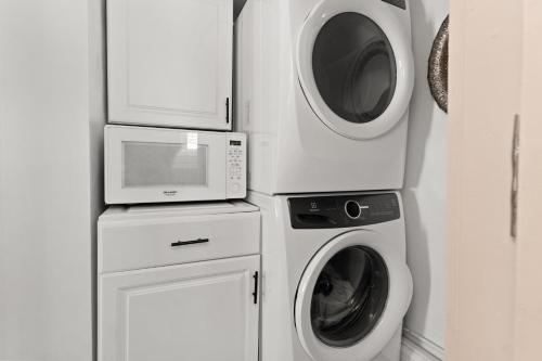 a kitchen with a washing machine and a microwave at The Wishbone Steps to Beach Bunk House in Newburyport