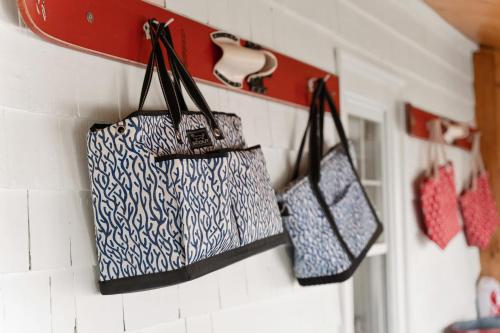 three handbags are hanging on a wall at The Wishbone Steps to Beach Bunk House in Newburyport