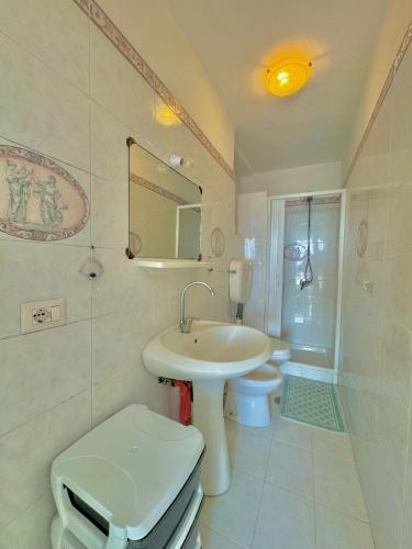 a white bathroom with a sink and a toilet at PonzaSmeralda Le Forna in Ponza