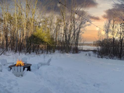 a fire pit in the snow in a snowy field at Winnisquam Landing Lakefront Firepit Deck in Tilton