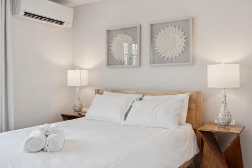 a bedroom with a bed with white sheets and two lamps at Winnisquam Landing Lakefront Firepit Deck in Tilton