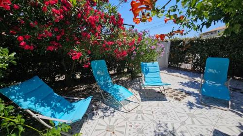 un grupo de sillas sentadas en un patio con flores en Maison Bord de Mer et Piscine, en Frontignan