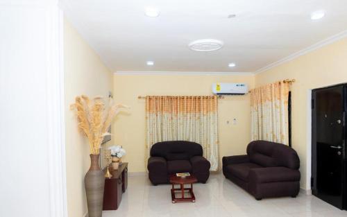 a living room with two chairs and a tv at Beautiful, serene and relaxing, 3bd rm, 3 Guest in Kweman