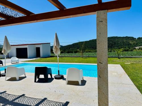 a patio with chairs and a swimming pool at Casa Carlindo - Private Pool - Nature & Calm in Ferreira