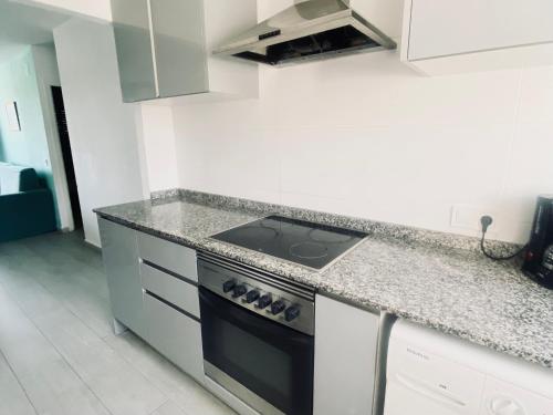 a kitchen with a stove and a counter top at Turyva Tarongers 5 - Modern 1-Bed Apartment & 5 Min to Peníscola Beach in Peñíscola