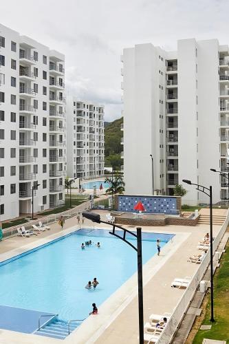 a large pool with people swimming in it with buildings at Agradable Apartamento Turístico Aqualina en Girardot in Girardot