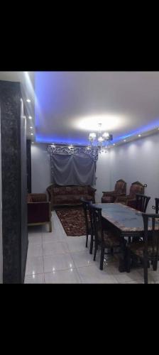 a dining room with a table and chairs and a blue light at عبق التاريخ هاوس in Rujm al Ḩāwī