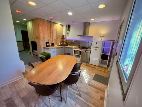 une cuisine avec une table en bois et quelques chaises dans l'établissement Appartement sur les hauteurs de Clermont-Fd, à Orcines