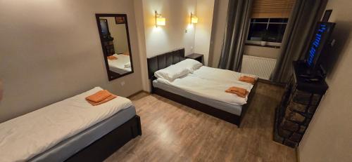 a small room with two beds and a mirror at Restauracja Bizaree in Debrzno