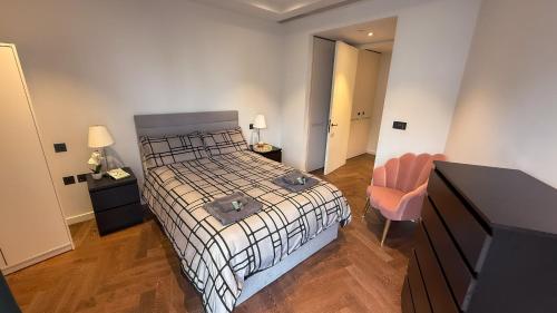 ロンドンにあるLuxury apartment steps from Battersea Power ST and close to Victoria & Chelseaのベッドと机と椅子のある寝室