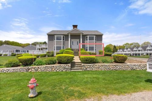 a house with a fire hydrant in the front yard at Snug Seaside Views From Couch Walk to Beach in Rye