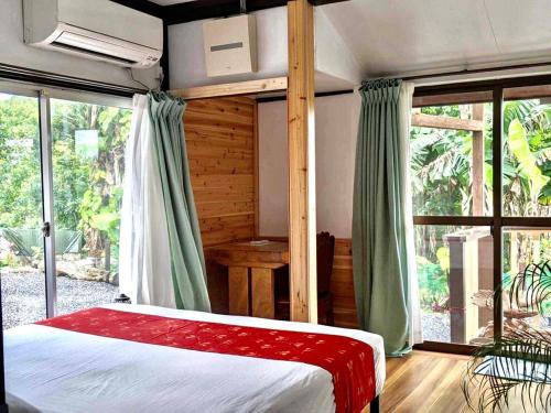 a bedroom with a bed and a large window at Family house プール付オーシャンビュー Amami "Birdland Nature Resort" in Amami