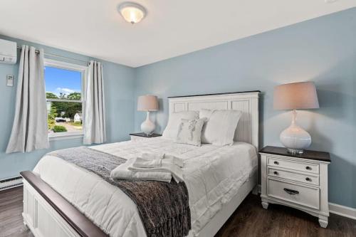 a bedroom with a bed with two lamps and a window at The Sunrise Deck Ocean Views Private Deck in Rye