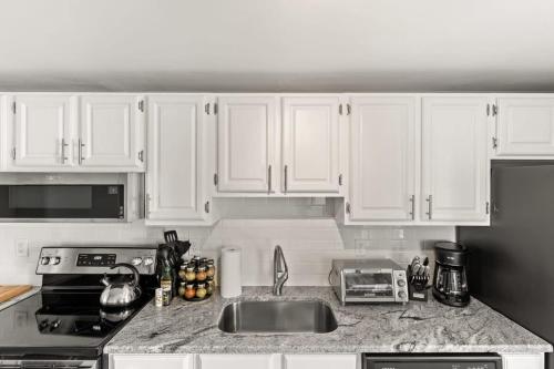 a kitchen with white cabinets and a kitchen sink at The Sunrise Deck Ocean Views Private Deck in Rye