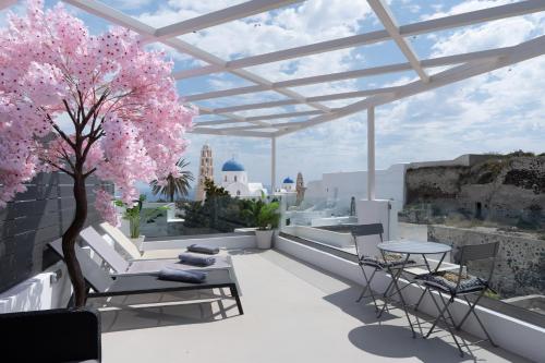 a rooftop patio with a pink tree and tables and chairs at Marillia's elegance residence in Mesaria