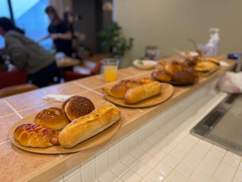 a counter with plates of bread and pastries on it at 金春in KONPAL in Kikuyo